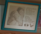 Partial Gore Screaming Show screenshot.A closely cropped image of a background element. It's a framed photo of a man with glasses crossing his arms, with text that is too small to be legible to the right. Below the text is an image of a CD and a signature.